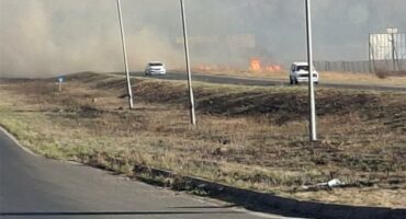 A veld fire causing a lot of smoke next to a road
