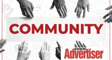 A black and white image of hands of different shades reaching into the word Community in red and the Boksburg Advertiser logo in the bottom right corner.