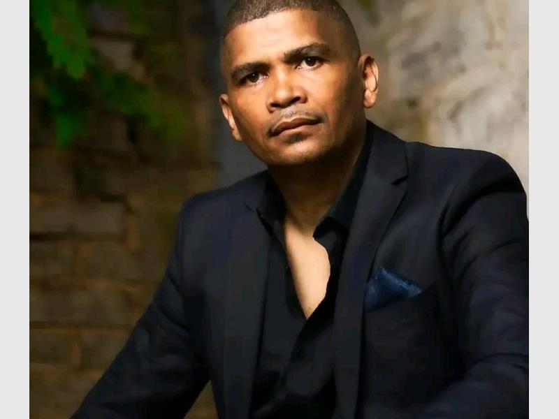 A man wearing a black suit