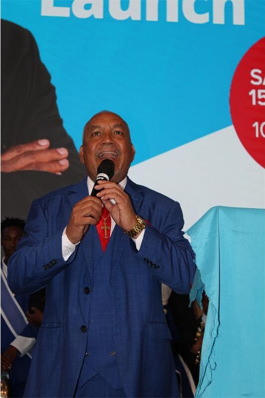 Black man holds a microphone with his mouth open