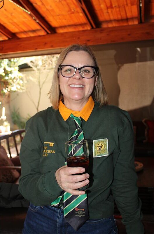 Woman wearing glasses and a Springbok jersey holding a glass