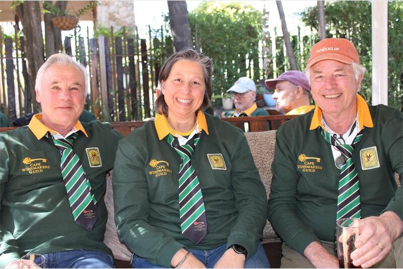 Two men and a woman wearing Springbok jerseys