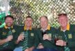 Group of four men wearing Springbok jerseys hold glasses