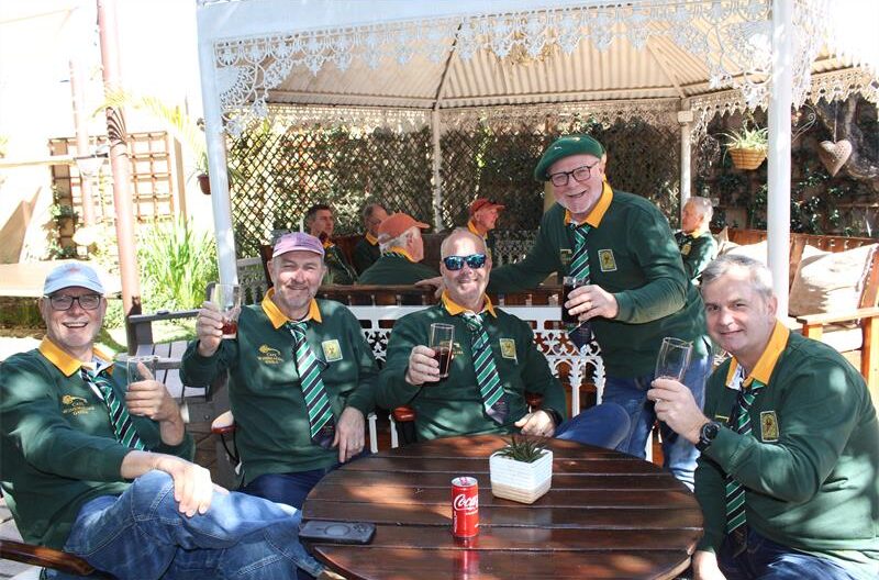 Group of men wearing Springbok jerseys holding their glasses up