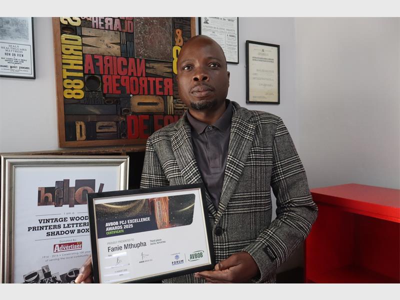 a man holding an award certificate