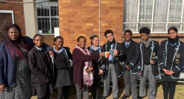 A group of boys and girls in school uniform who are the prefects of the school.