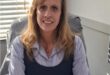 White woman sitting behind a desk