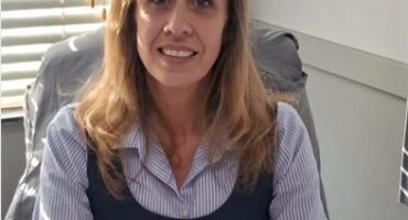 White woman sitting behind a desk