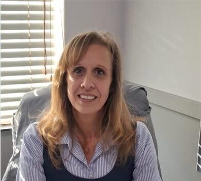 White woman sitting behind a desk