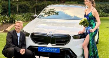Boy and girl posing at a white BMW