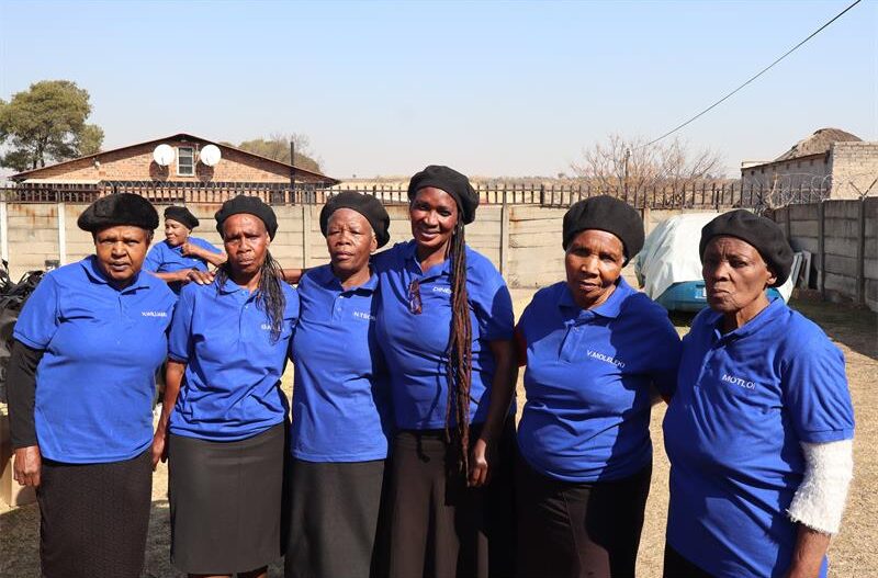 Elderlies in blue tops and black skirts