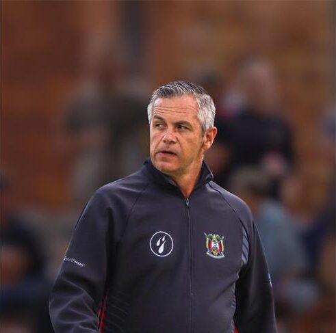 Grey haired man wearing a black jacket