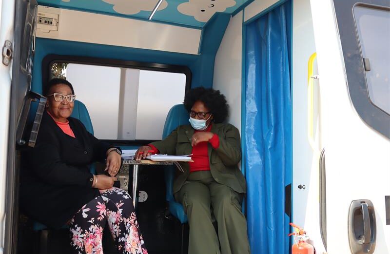 Two ladies sitting in mobile clinic. 