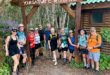 A group of male and female hikers standing under a sign reading Otter Trail.
