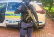 a policed officer in full uniform and carrying a rifle