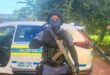 a policed officer in full uniform and carrying a rifle