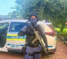 a policed officer in full uniform and carrying a rifle