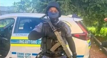a policed officer in full uniform and carrying a rifle