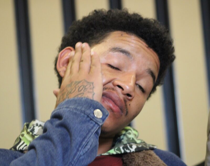 a man holding his head with his right hand