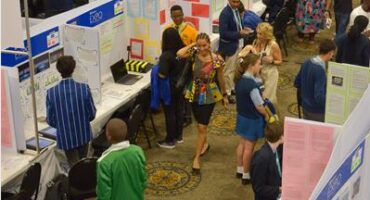 Learners standing at different stalls in a hall