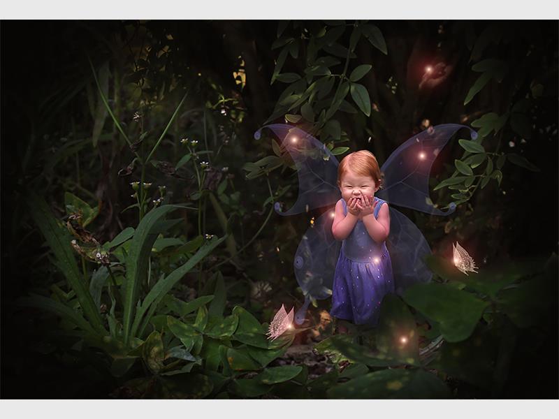 A fairy garden with lights and a fairy.