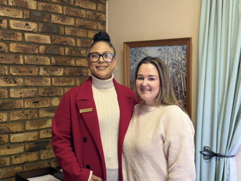 Two women one coloured and other white smiling