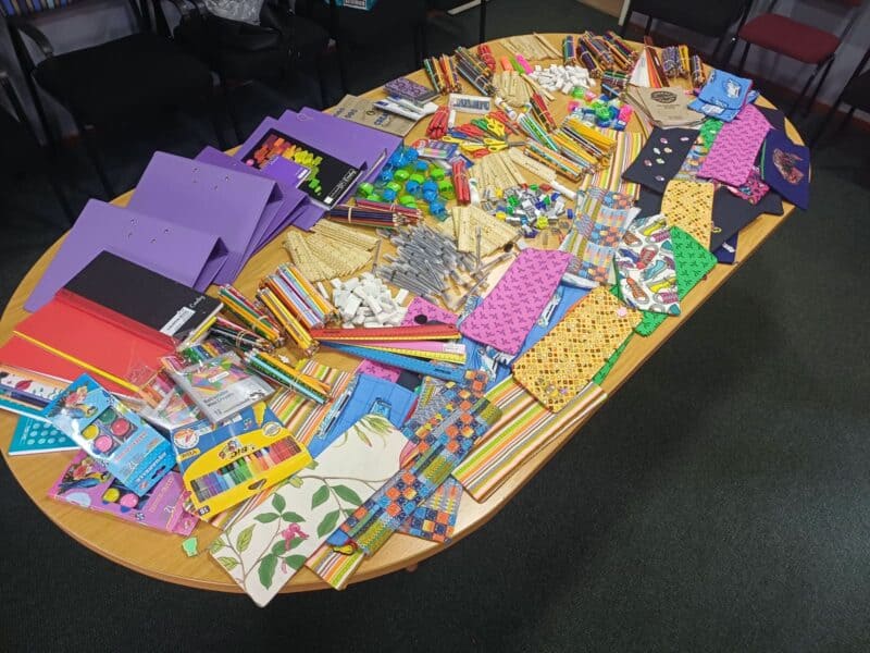 A table covered with colourful pencil cases and stationery.