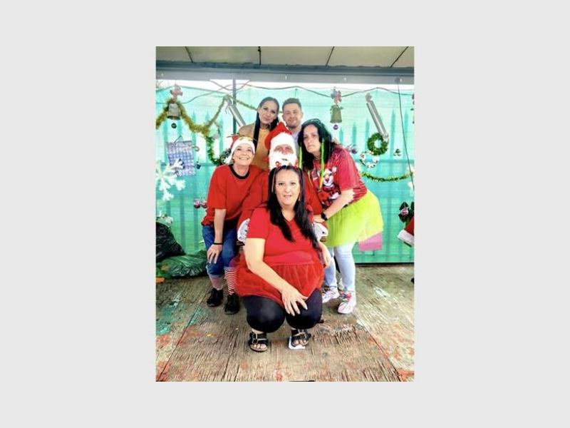 A group of people wearing Christmas shirts and hats.