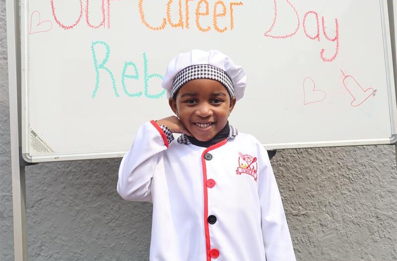A small girl dressed like a chef