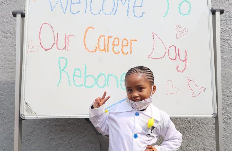 A small girl child wearing a white dust coat