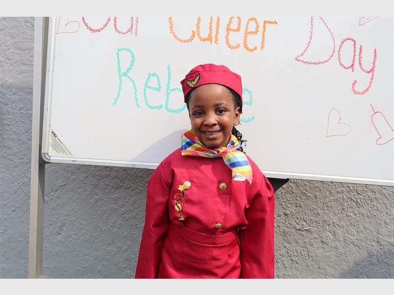 A small girl dressed in red airhostess clothes