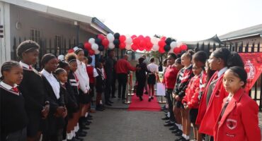 Learners waiting at the entrance of the school to welcome guests