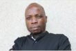 A head and shoulders photo of a black male wearing a black shirt and looking at the camera