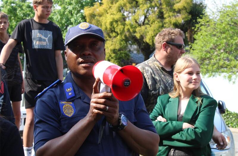 Uniformed officer speaking on a loud speaker