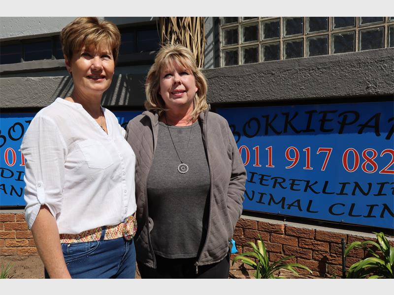 two women standing outside a building