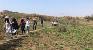 A group of school learners walking Melville Koppies.