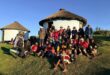 A group of hikers standing in front of a hut house