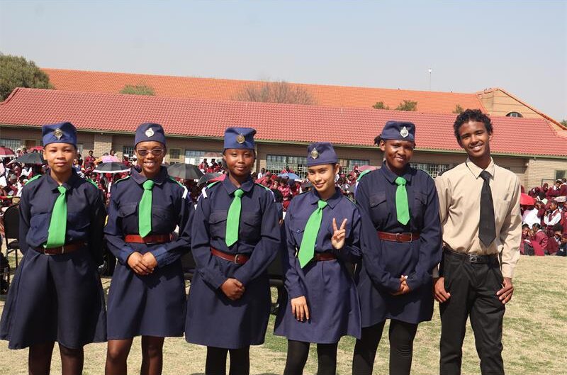 Girls wearing blue uniform and boy wearing brown