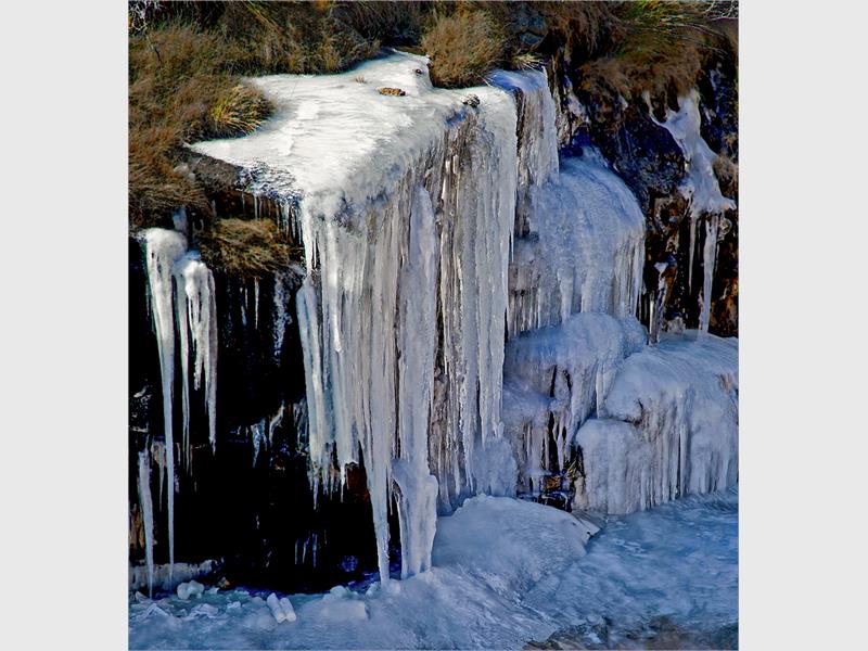 A photo of ice frozen on rocks.