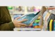 An image of pair of hands holding a bag of dog food in a supermarket.