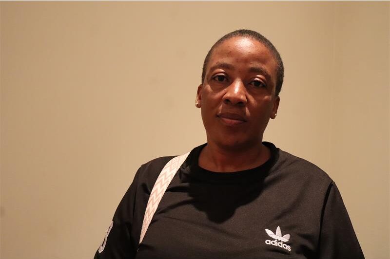 A lady with short hair, wearing a black adidas top