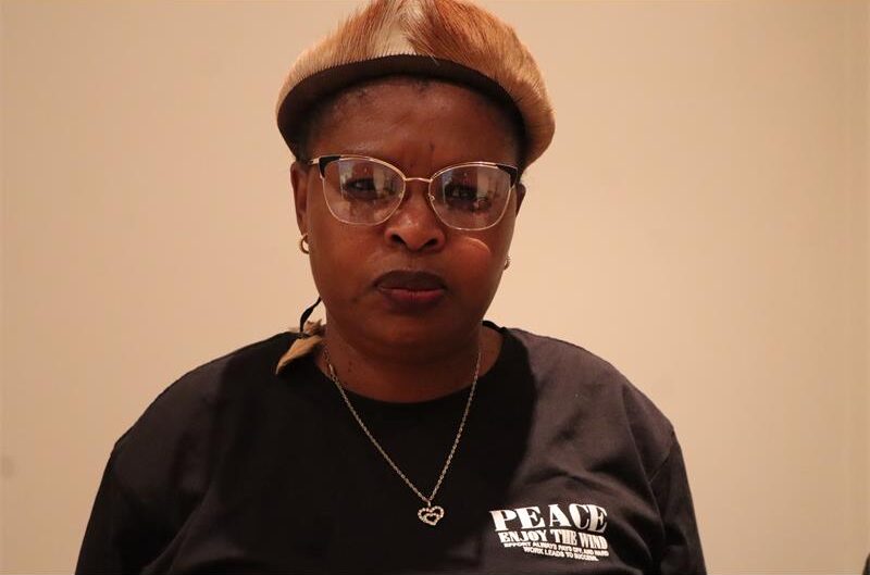 A lady wearing a black tshirt a zulu headband
