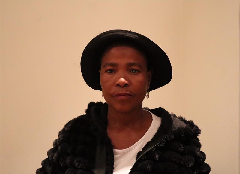 A lady wearing a black hat and a black jacket