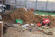 A picture showing a mound of sand with a red toy motorcycle standing among the sand
