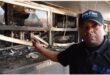 a man standing next to a fire damaged property