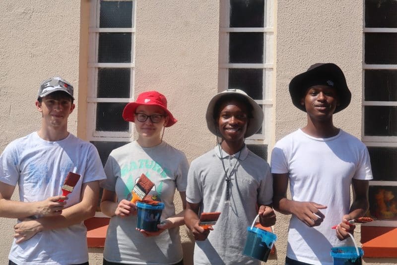 Group of youths holding paint brushes