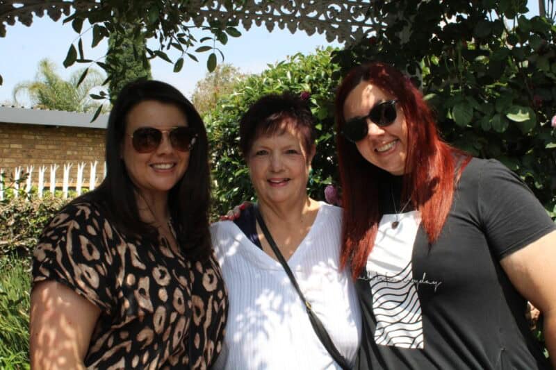 Three women standing in a garden