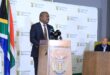 Black man standing at a podium addressing an audience