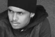 A black and white picture of a boy wearing a jacket and hat