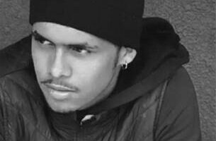 A black and white picture of a boy wearing a jacket and hat